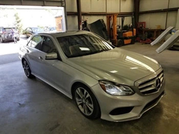 2016 Mercedes E350 sedan inside bay doors of an automotive shop